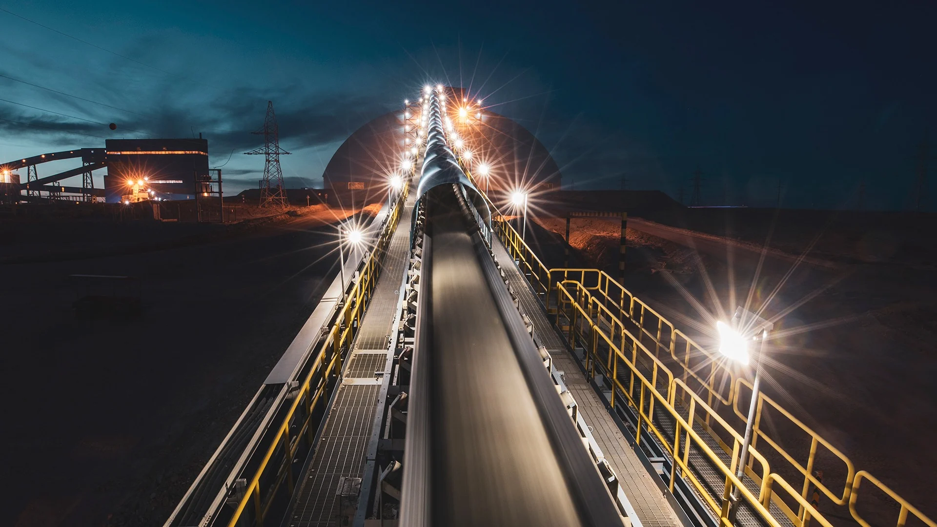 Illuminated conveyor extending through a concentrator at night